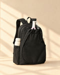 The Icacos Backpack in black with a padel racket in its drawstring racket pouch