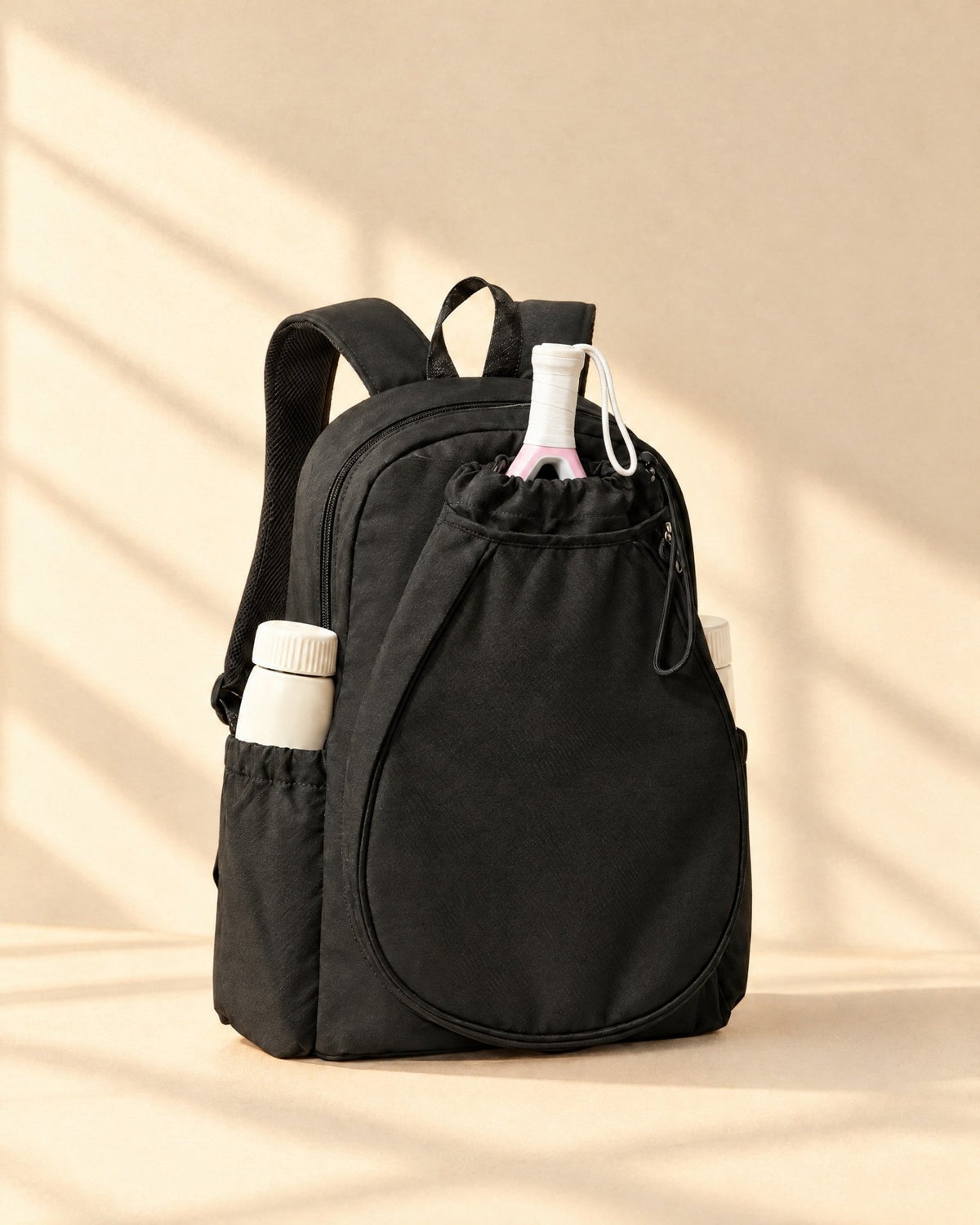 The Icacos Backpack in black with a padel racket in its drawstring racket pouch