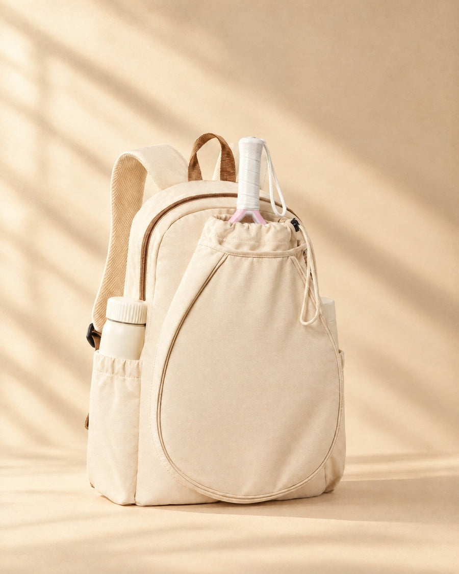 The Icacos Backpack in cream with a padel racket in its drawstring racket pouch