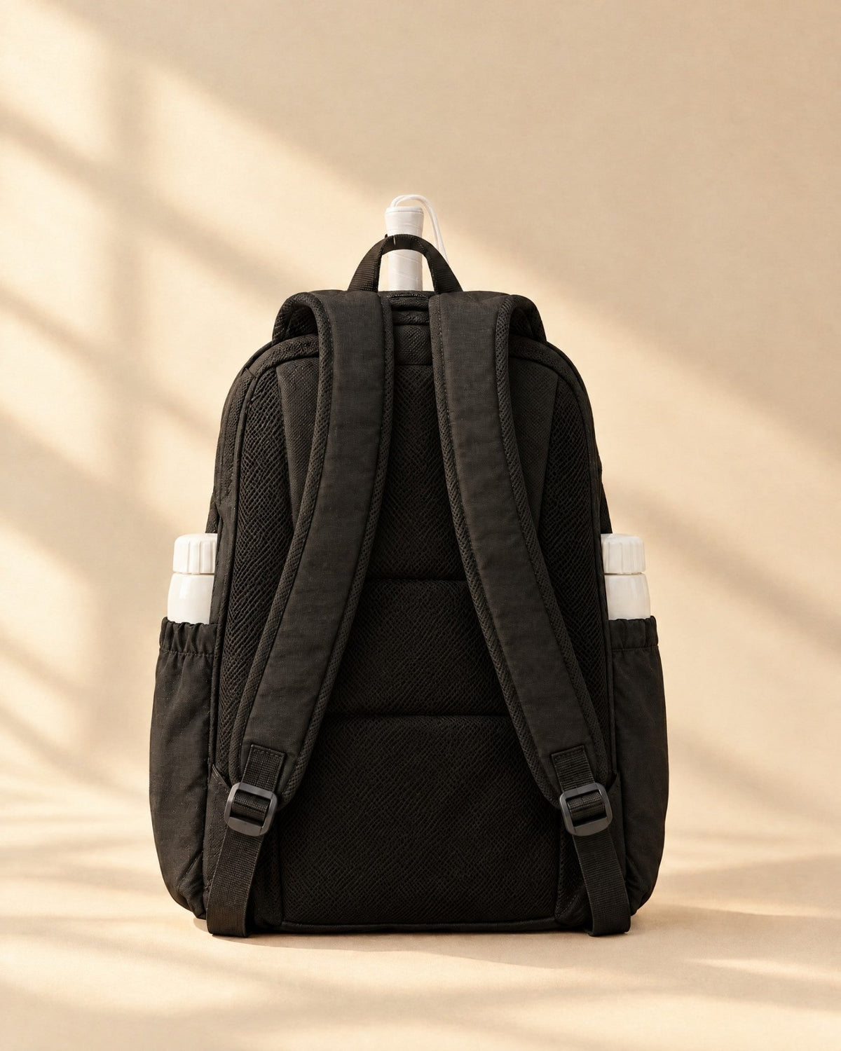 The back of the Icacos Backpack showing its straps and the top of a padel racket grip