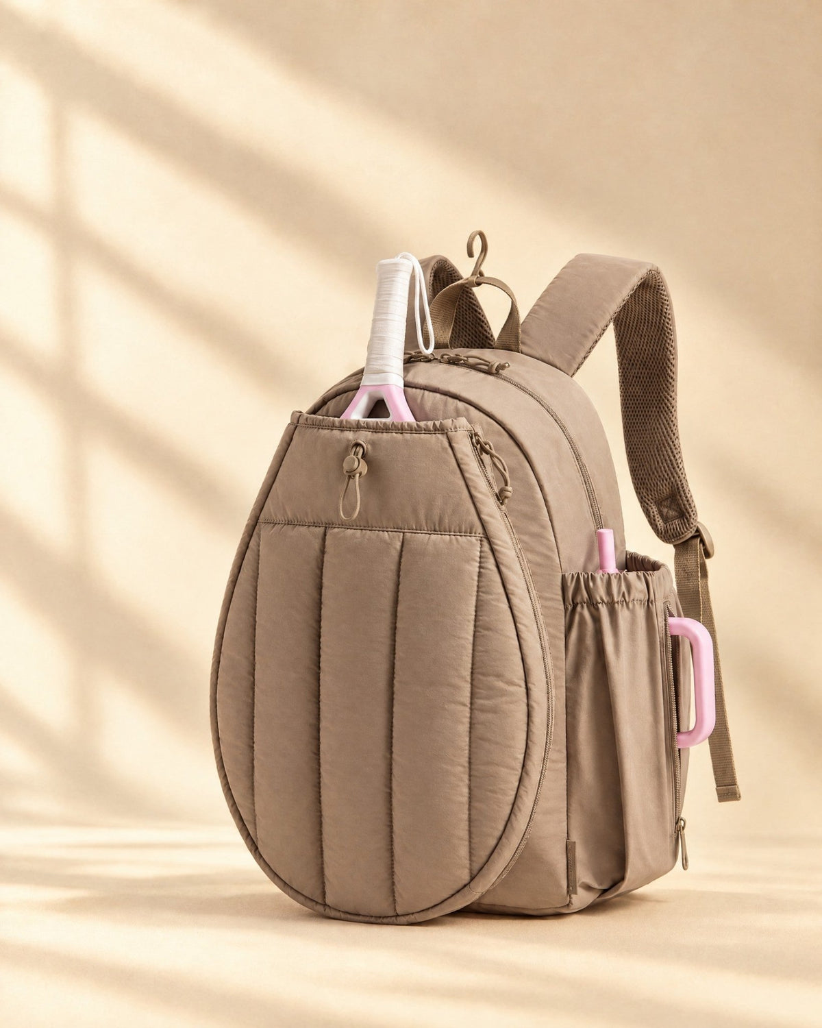 The Papagayo Backpack in brown, quilted, with a padel racket in its front pocket
