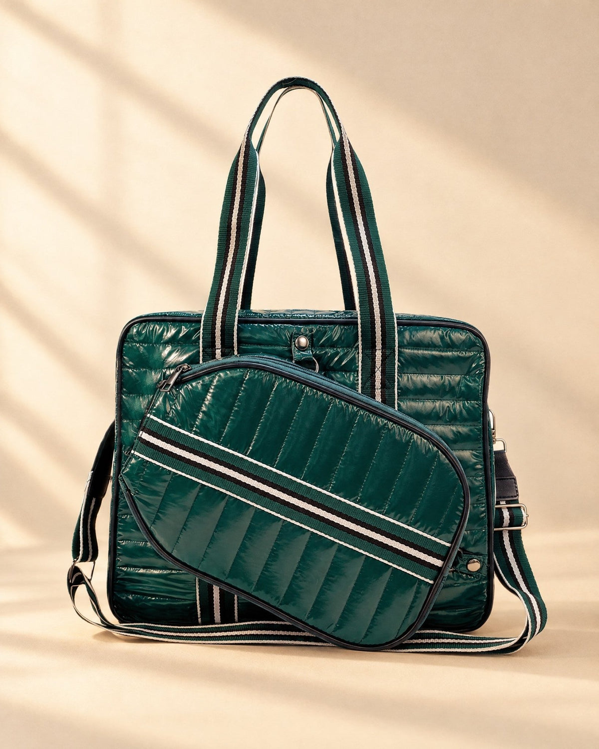 The Roqueta Bag in dark green glossy quilting with striped handles