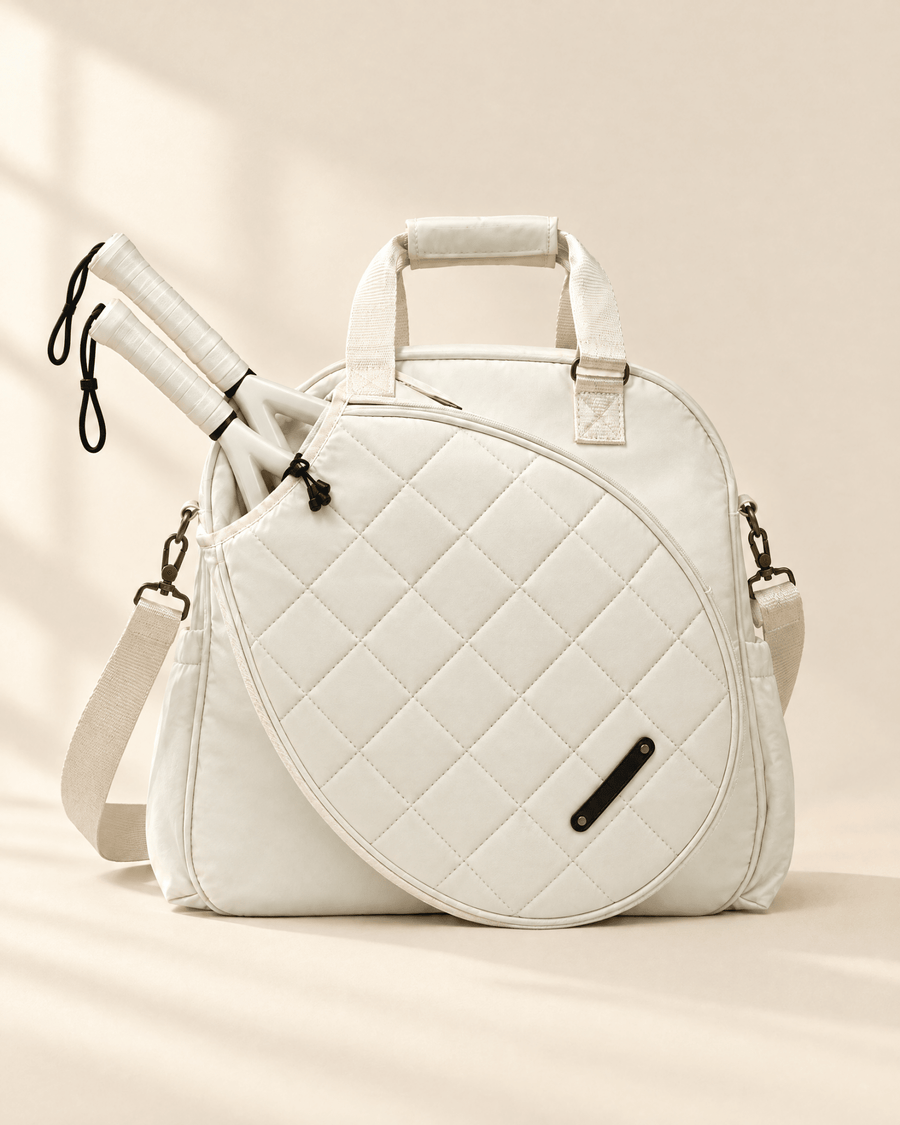 The Las Brisas Racket Bag in white, with two padel rackets in the quilted front compartment